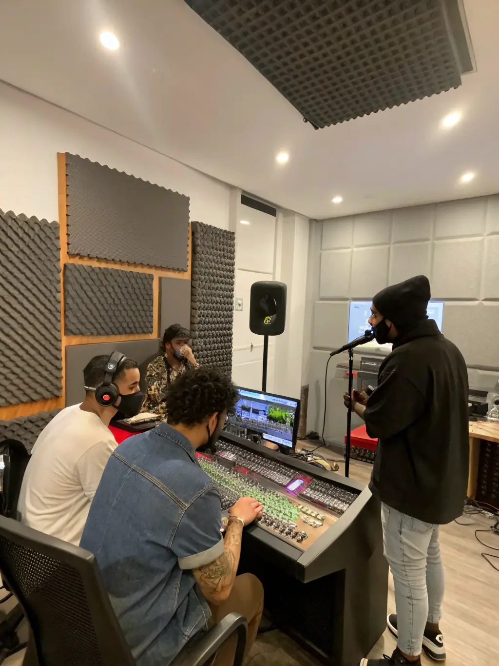 A photo of a diverse group of musicians collaborating in a modern recording studio, showcasing AMICAL MUSIC PRODUCTIONS' commitment to supporting emerging artists.