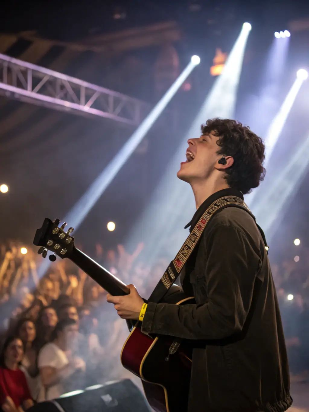 A photograph capturing a live music performance organized by AMICAL MUSIC PRODUCTIONS, showcasing an emerging artist on stage with a vibrant audience.